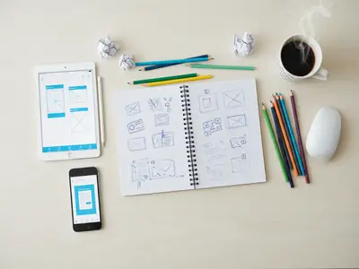 Sketches of app screens on a desk